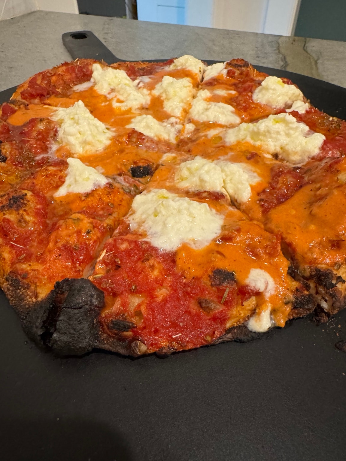 Greg's ricotta pizza on black peel