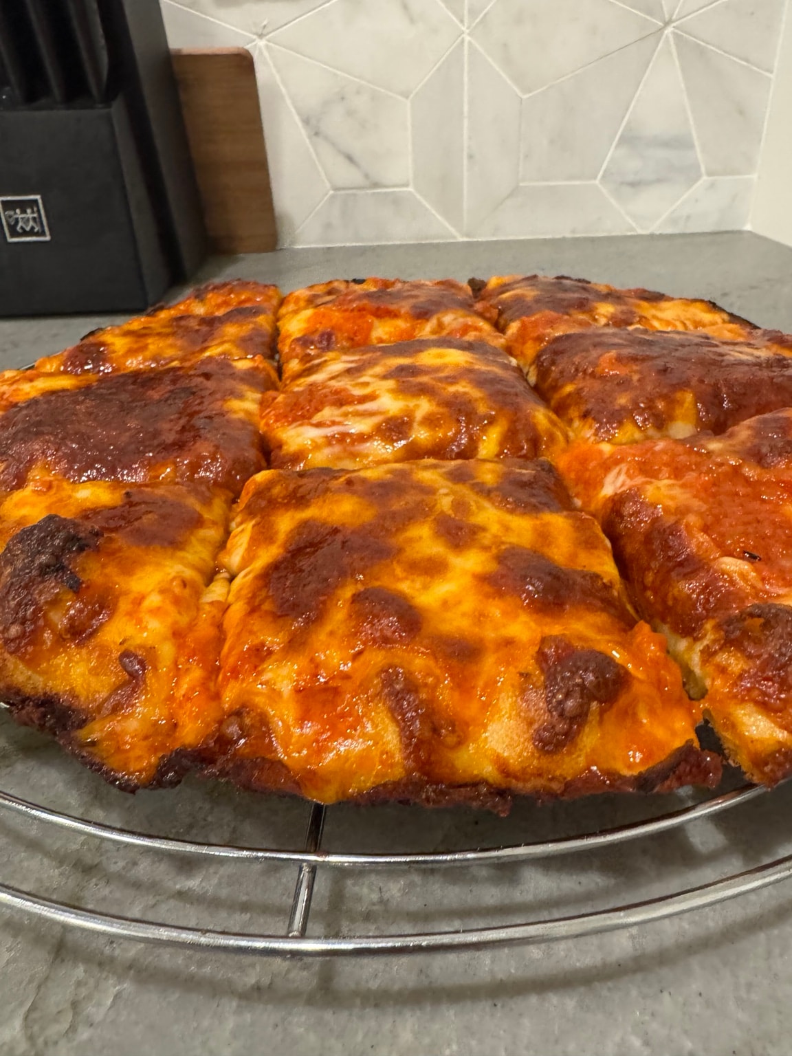 Fresh pepperoni pizza on cooling rack